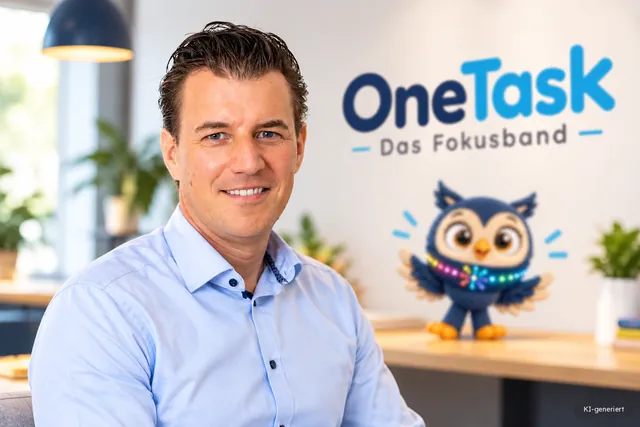 KI-generiertes Bild: Mirco Heinen, Gründer von One Task, lächelt im hellblauen Hemd. Hinter ihm steht das One-Task-Logo an der Wand, auf dem Tisch sitzt die Eule.